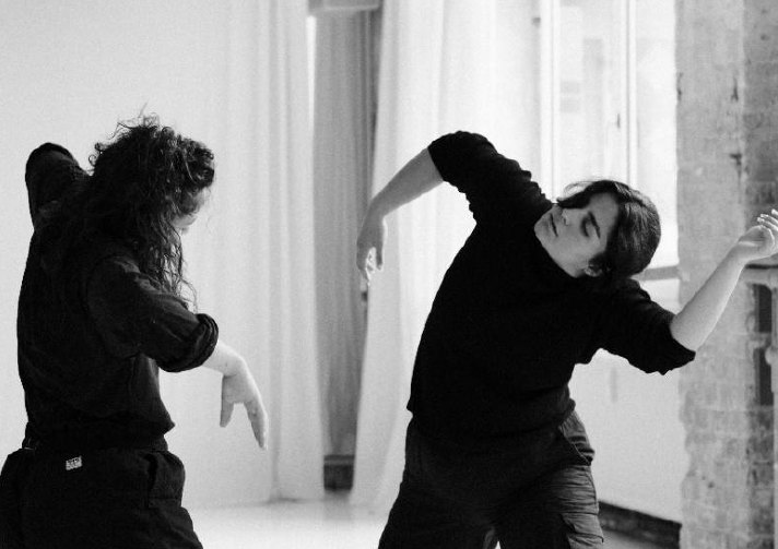 Duo in black against white curtains, black and white